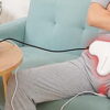 Man using a handheld prostate light therapy device at home